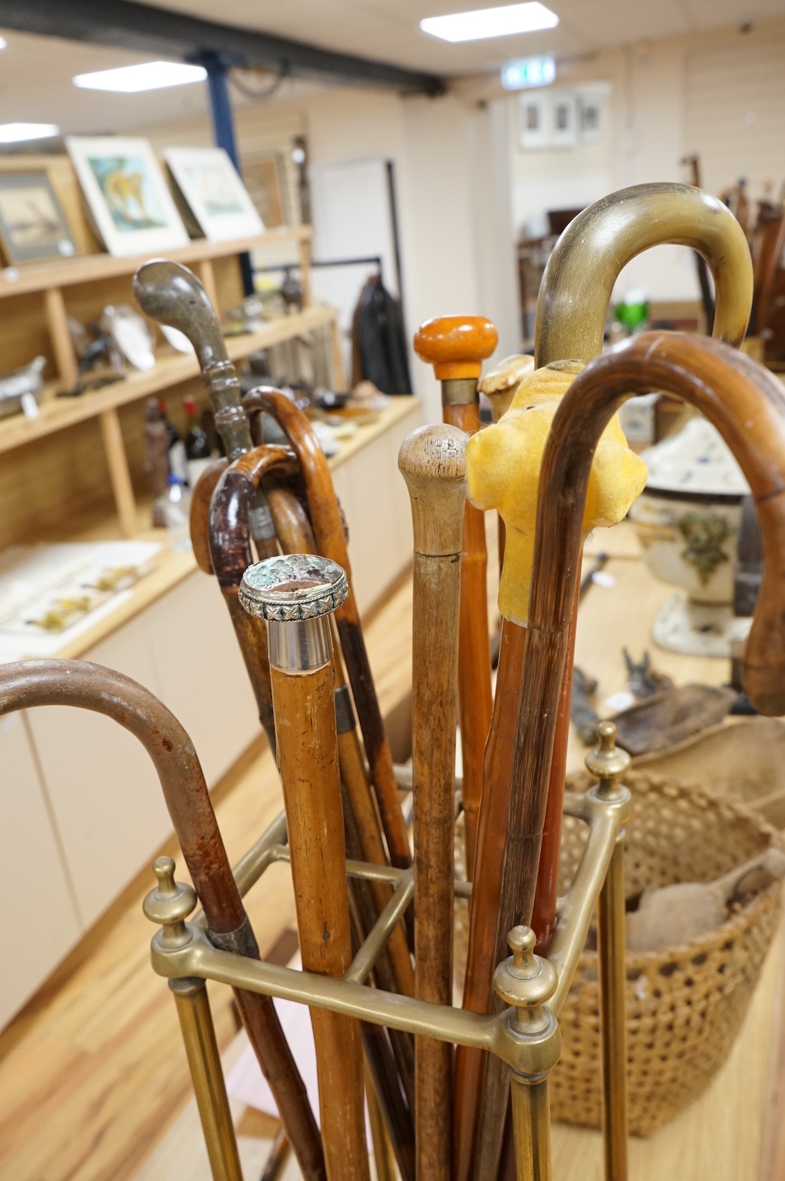 A collection of various walking sticks, some silver mounted and a brass stick stand, 67cm high